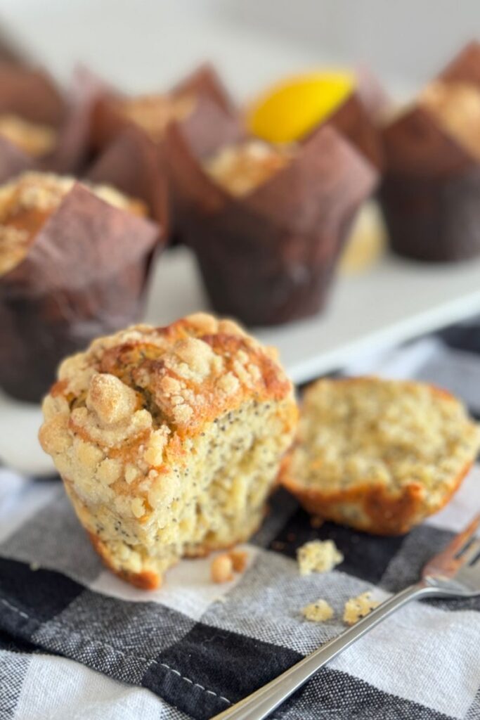 seeing the inside of a Lemon Poppy Seed Muffin with Streusel with a fork on a tea towel