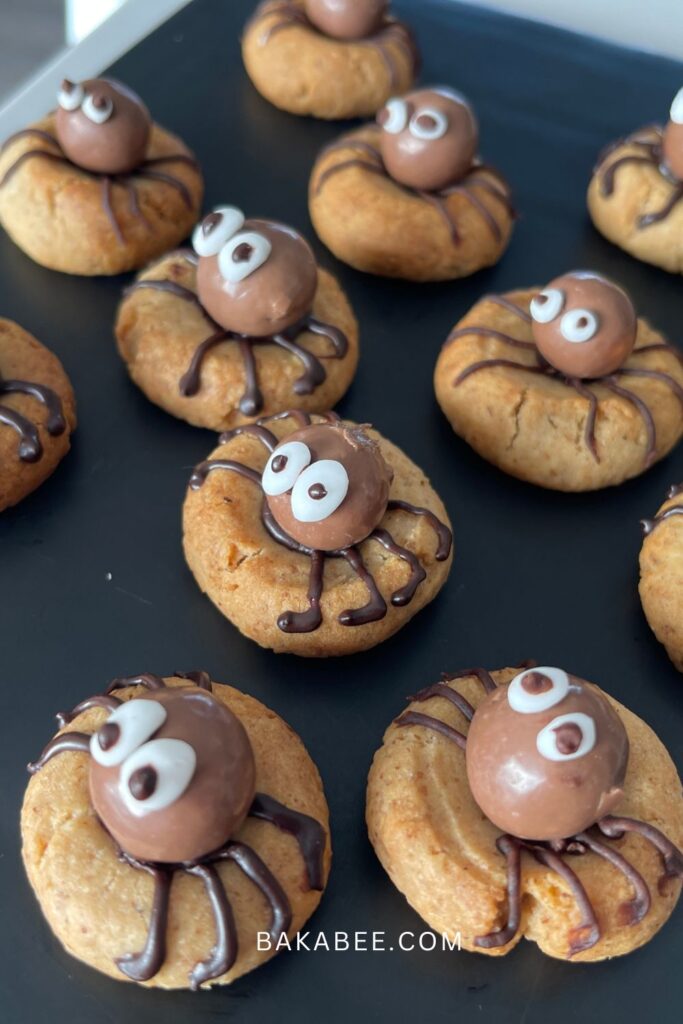 Spider cookies on a black serving plate