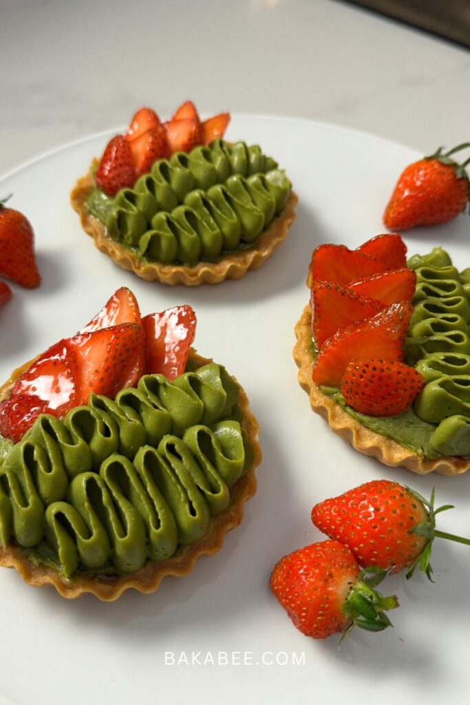 matcha pastry cream and sliced strawberries on shortcrust pastry tart shells