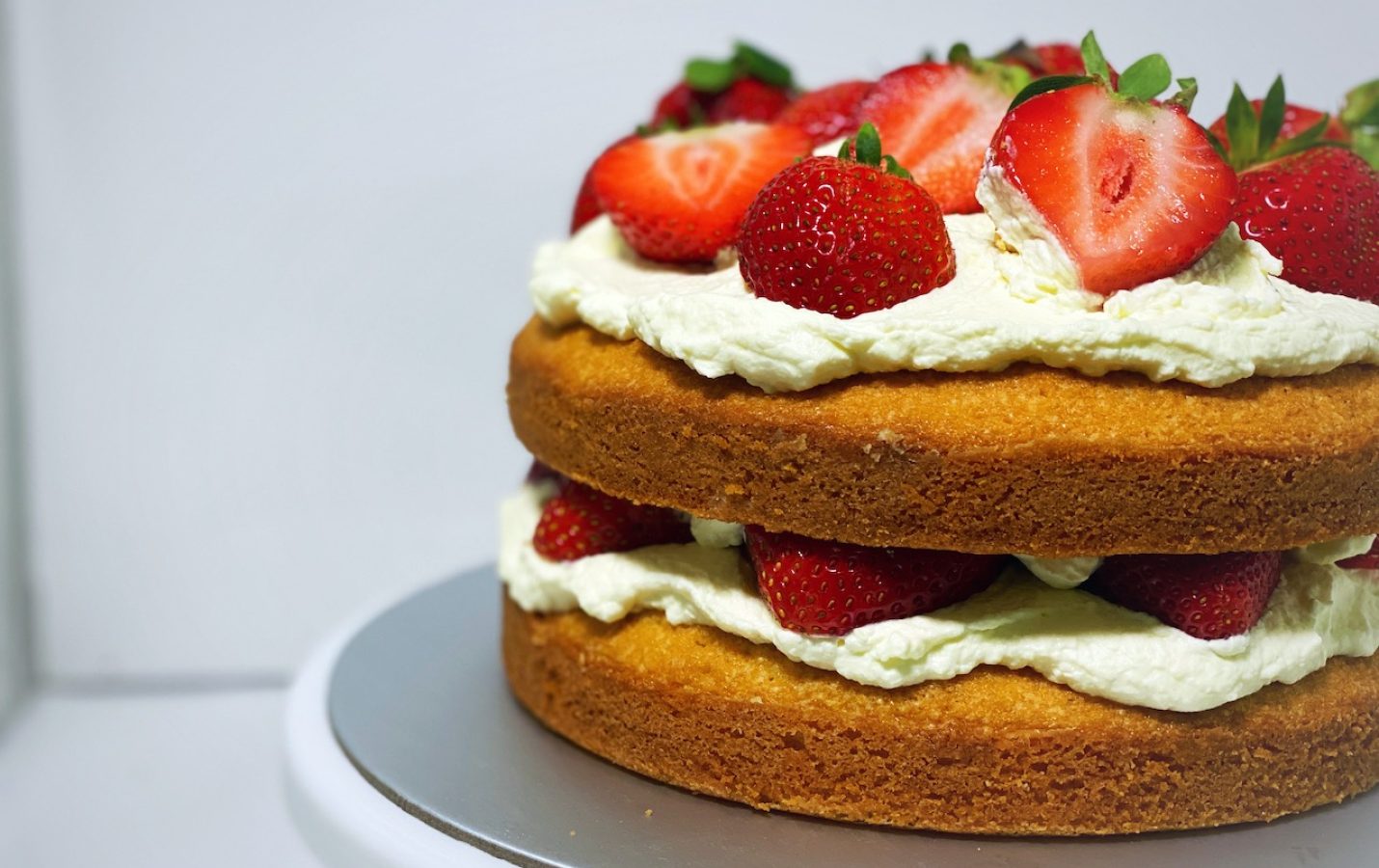 Classic Victoria Sponge Cake with cream and fresh strawberries