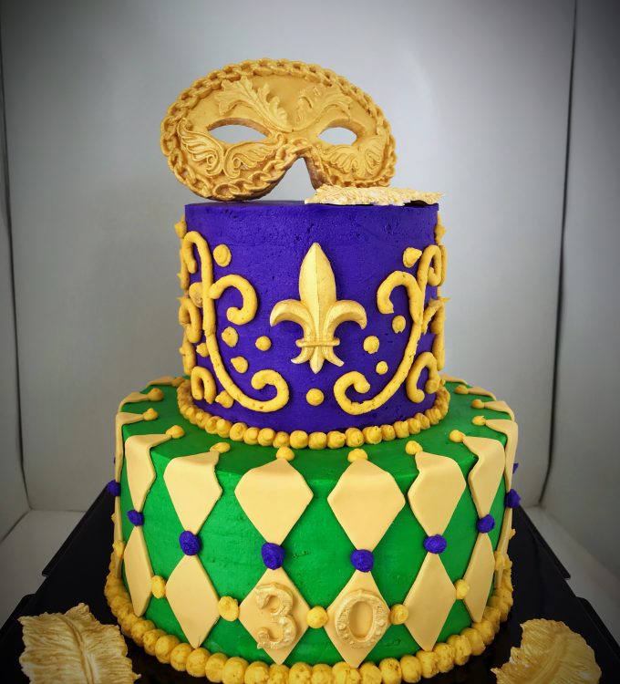 Mardi Gras 2-tier cake, decorated with a handcrafted gold mask, feathers and ornaments
