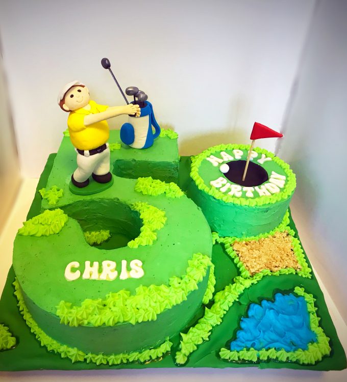 Vanilla sponge cake with fresh cream frosting, decorated with handcrafted golf themed decorations