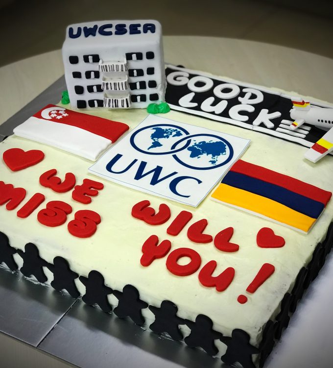 18" x 18" 2-layer vanilla cake with cream cheese frosting and a mini vanilla cake featured UWCSEA boarding house, decorated with hand made runway, an aircraft, UWC edible logo, Singapore flag, Armeniam flag, message and boarders