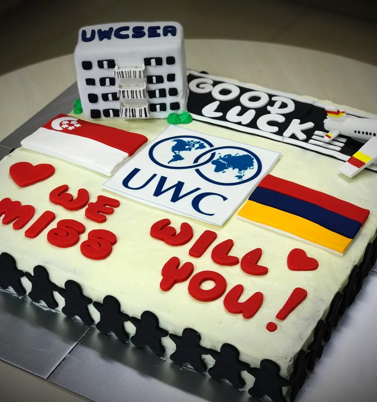 18" x 18" 2-layer vanilla cake with cream cheese frosting and a mini vanilla cake featured UWCSEA boarding house, decorated with hand made runway, an aircraft, UWC edible logo, Singapore flag, Armeniam flag, message and boarders