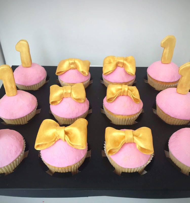 gold one and gold bows cupcakes